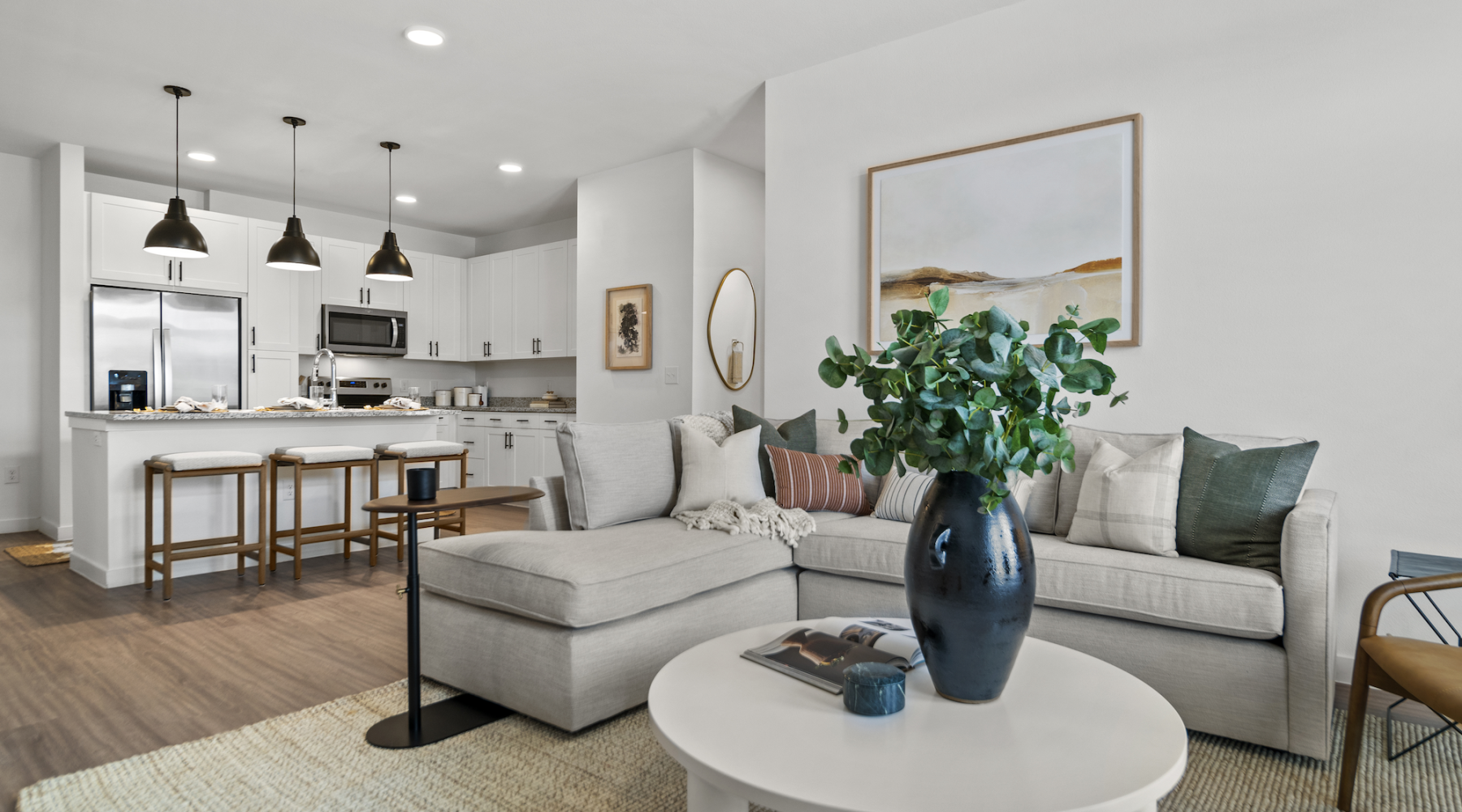 a living room with a wood floor a couch and a dining table