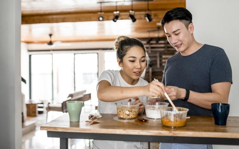 young couple eat at a standing table